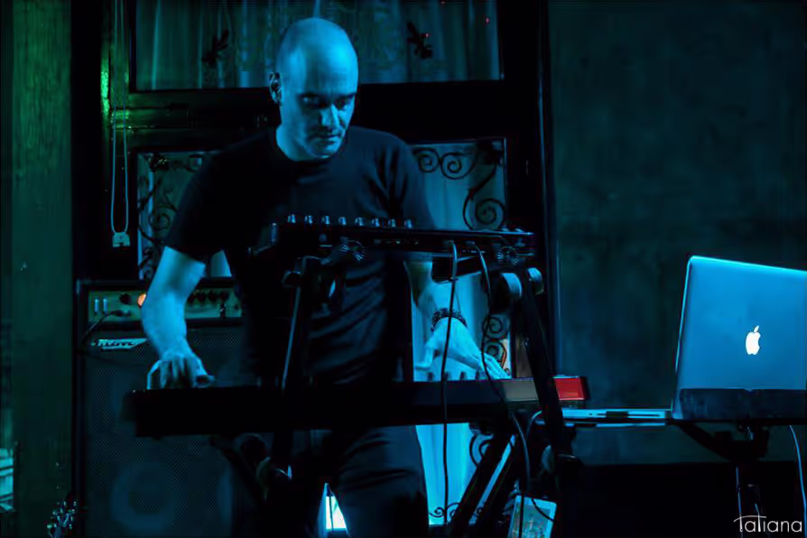 Alex (keys) passionately playing the keyboard instrument on stage, showcasing his skill and musical talent.